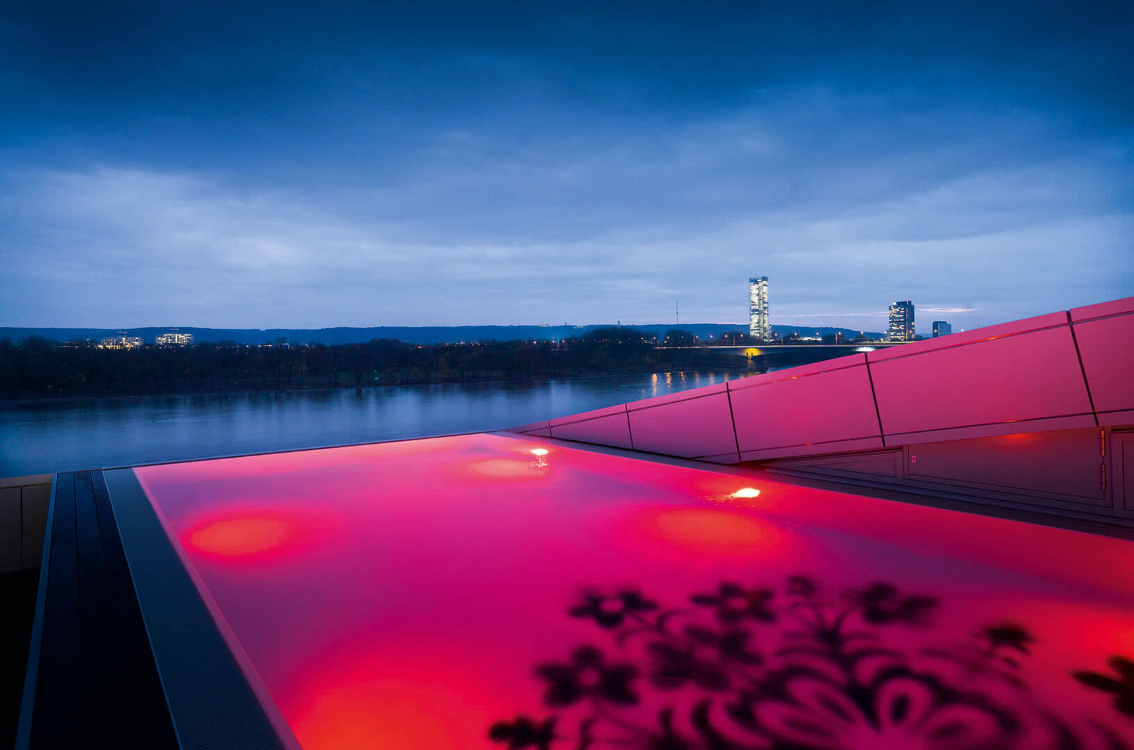 Rot leuchtender Infinity Pool mit Blick auf den Rhein
