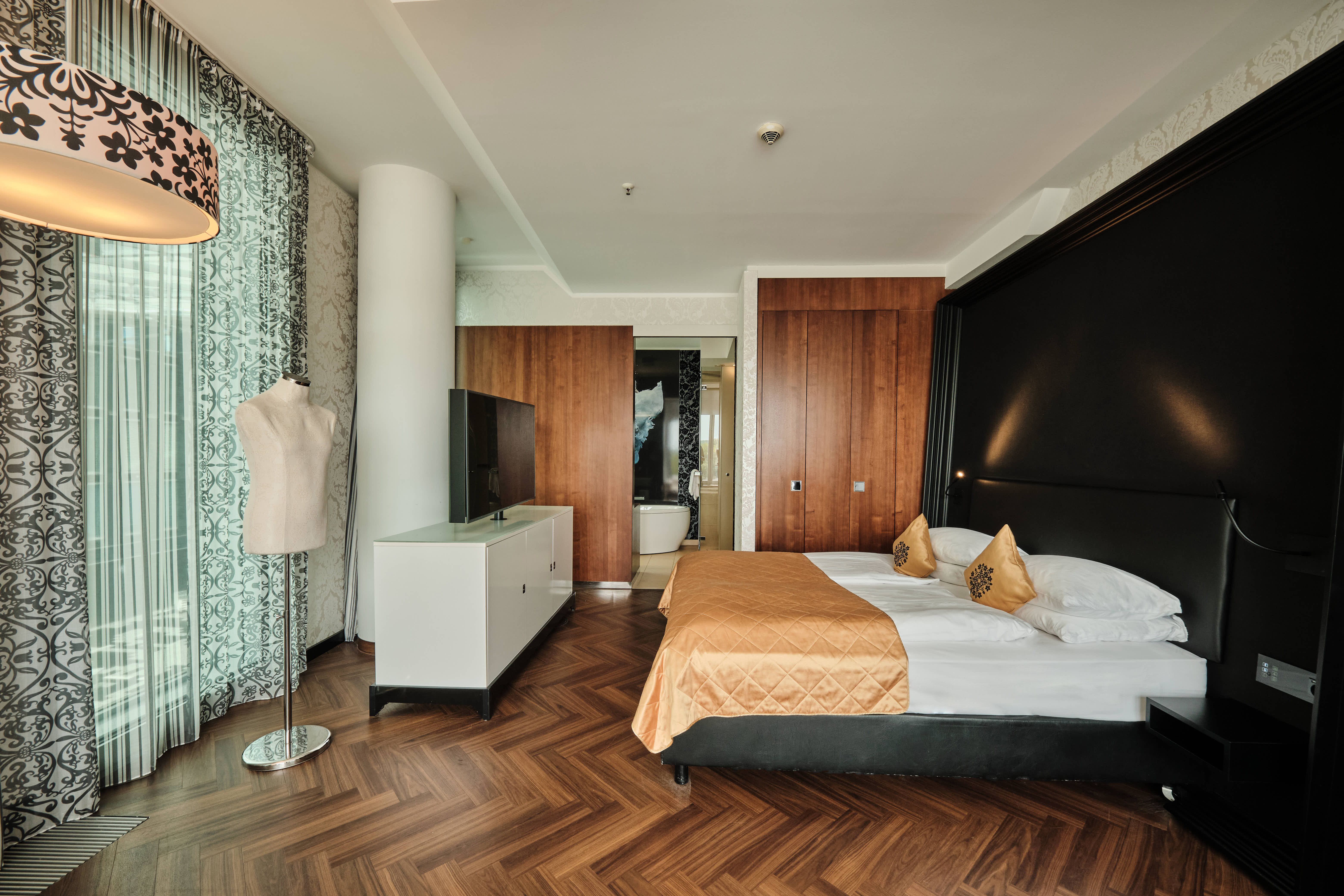 Schlafzimmer mit Bett und Fernseher in der Corner Suite.