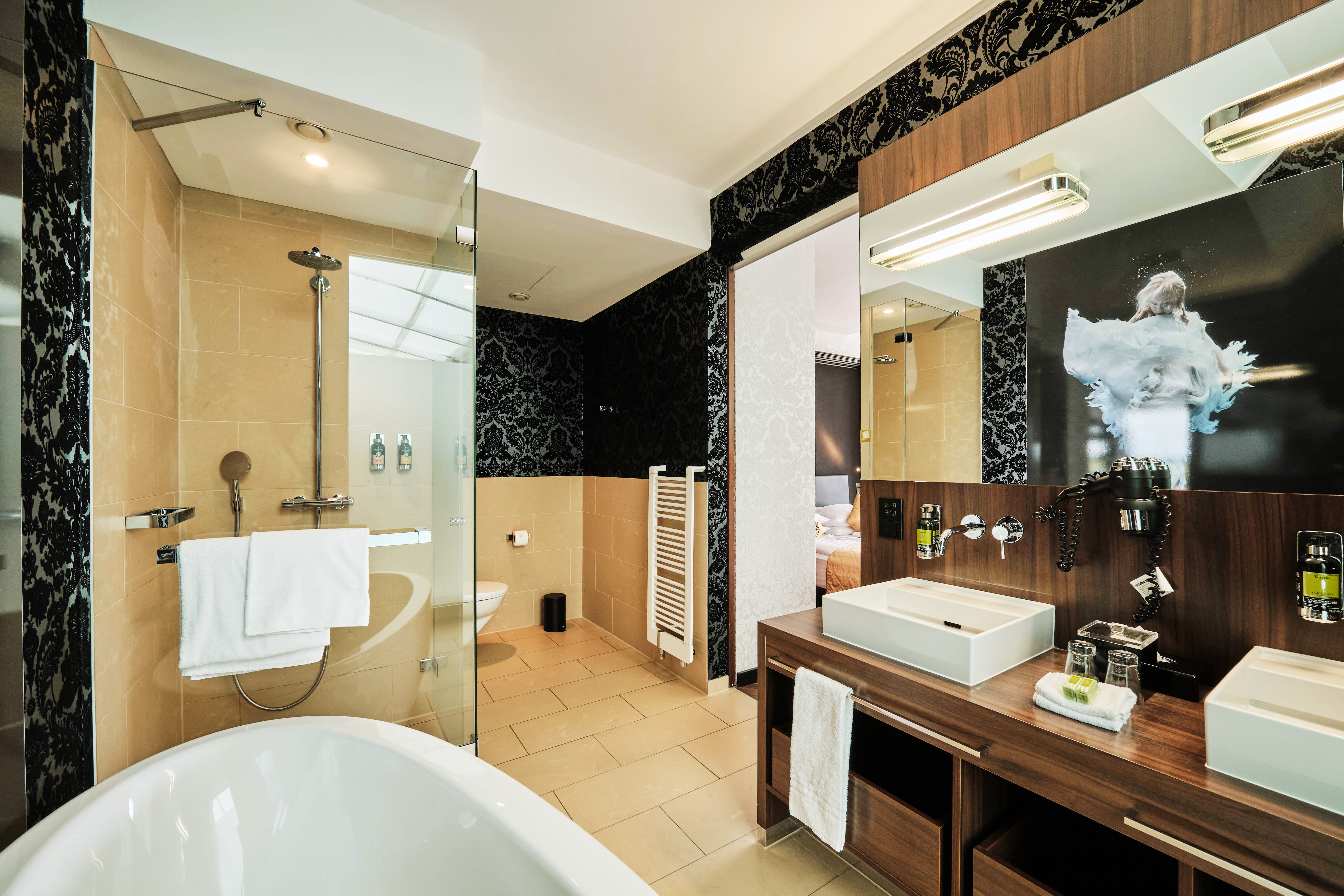 Badezimmer mit Dusche und Badewanne in der Corner Suite.