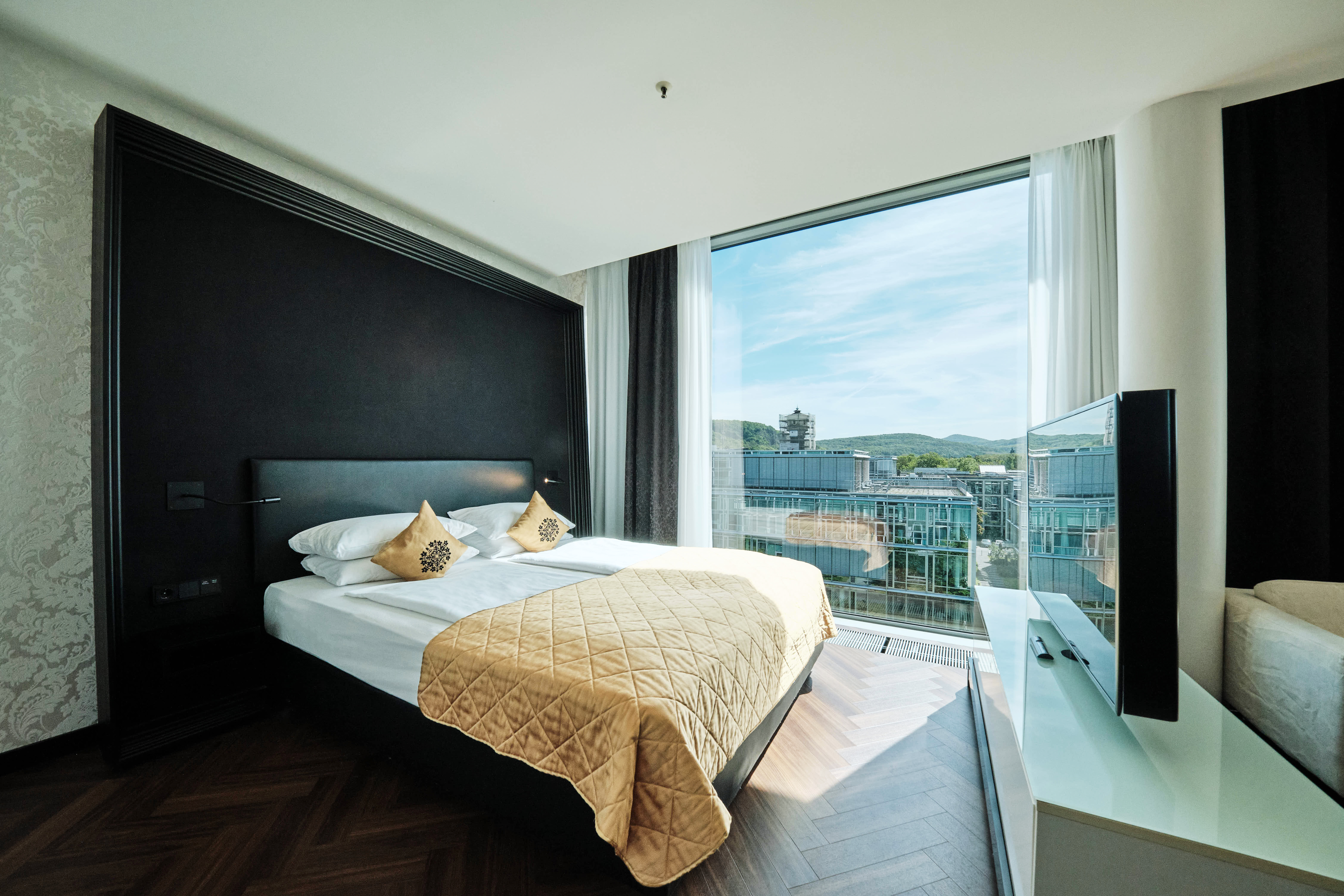 Schlafzimmer mit Bett und Ausblick aus der Junior Suite Deluxe.