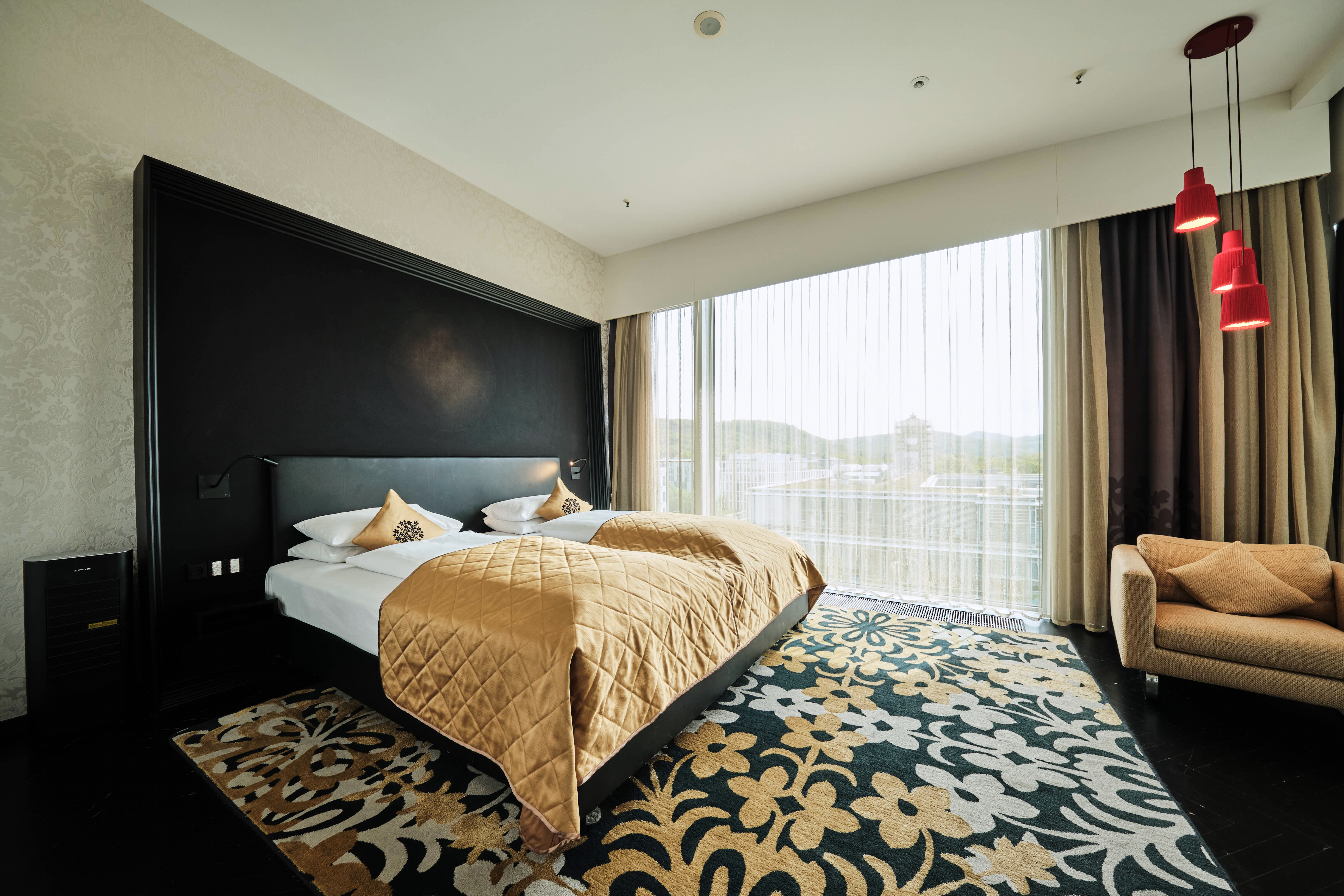 Schlafzimmer mit Bett und Sessel in der King Suite. 
