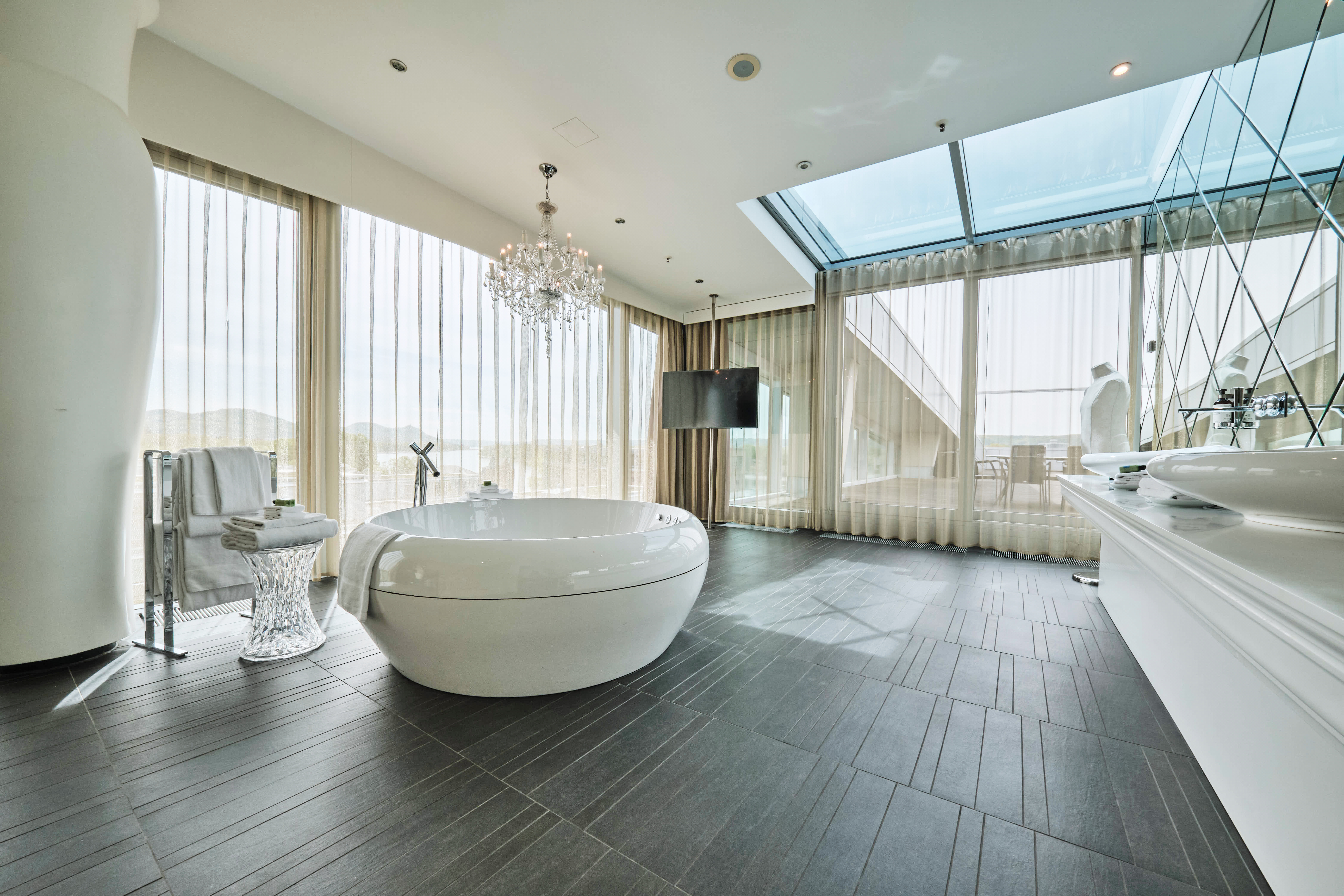 Badezimmer mit Whirlpool, Säule und Waschtisch in der King Suite.