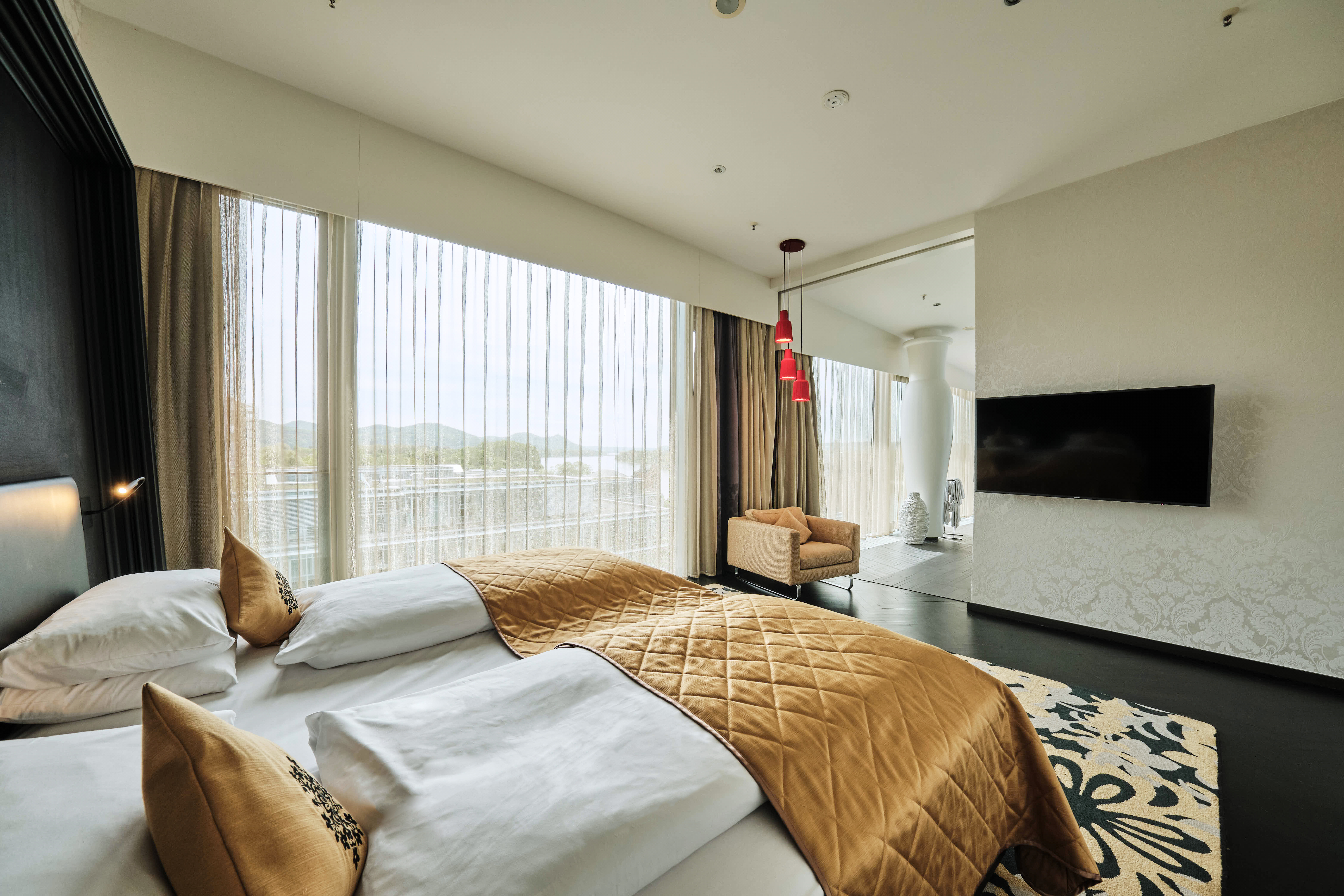 Schlafzimmer mit Bett, Fernseher und Sessel in der King Suite.