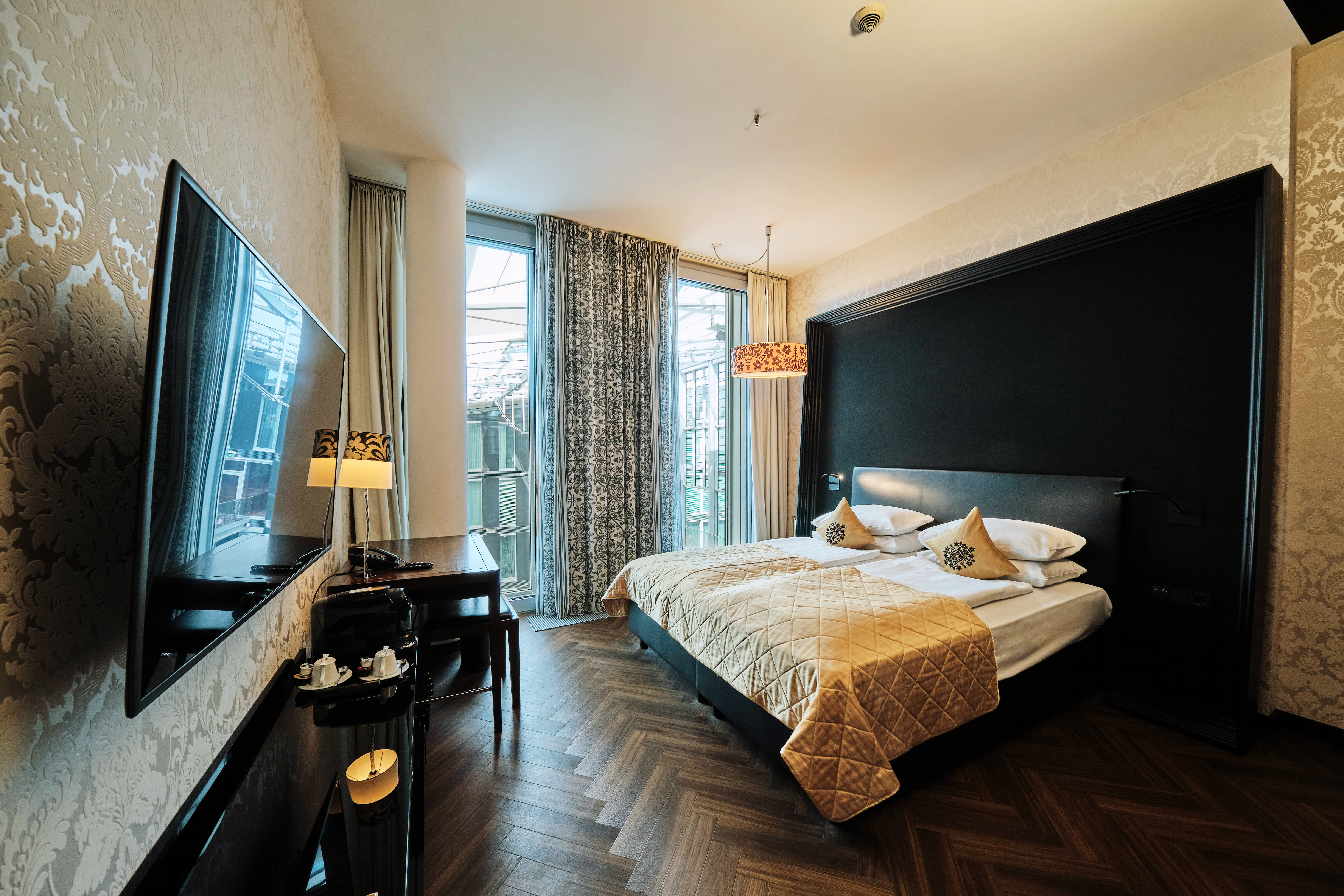 Schlafzimmer mit Bett, Fernseher und Schreibtisch im Premium Room. 