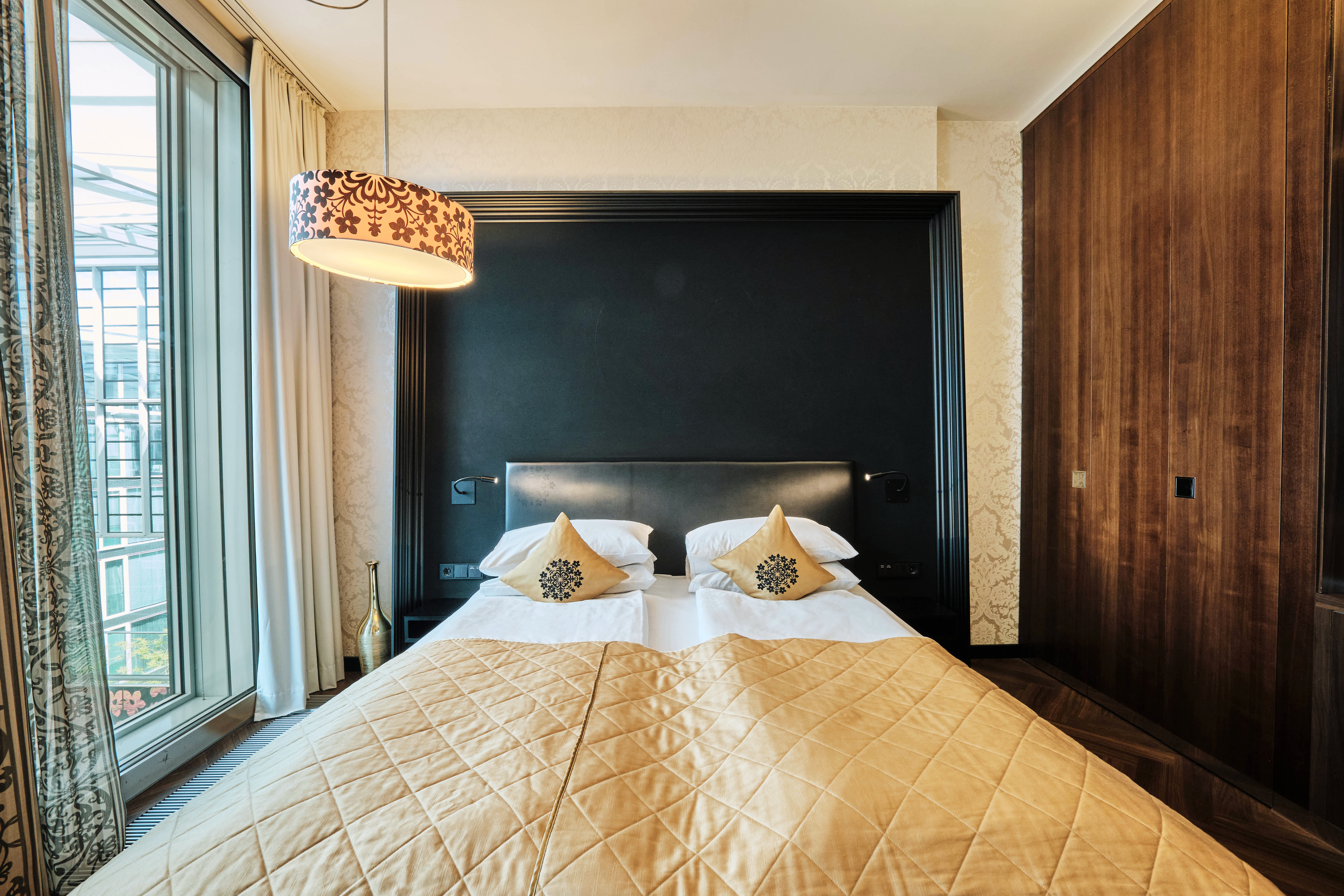 Schlafzimmer mit Bett und Kleiderschrank im Premium Room. 