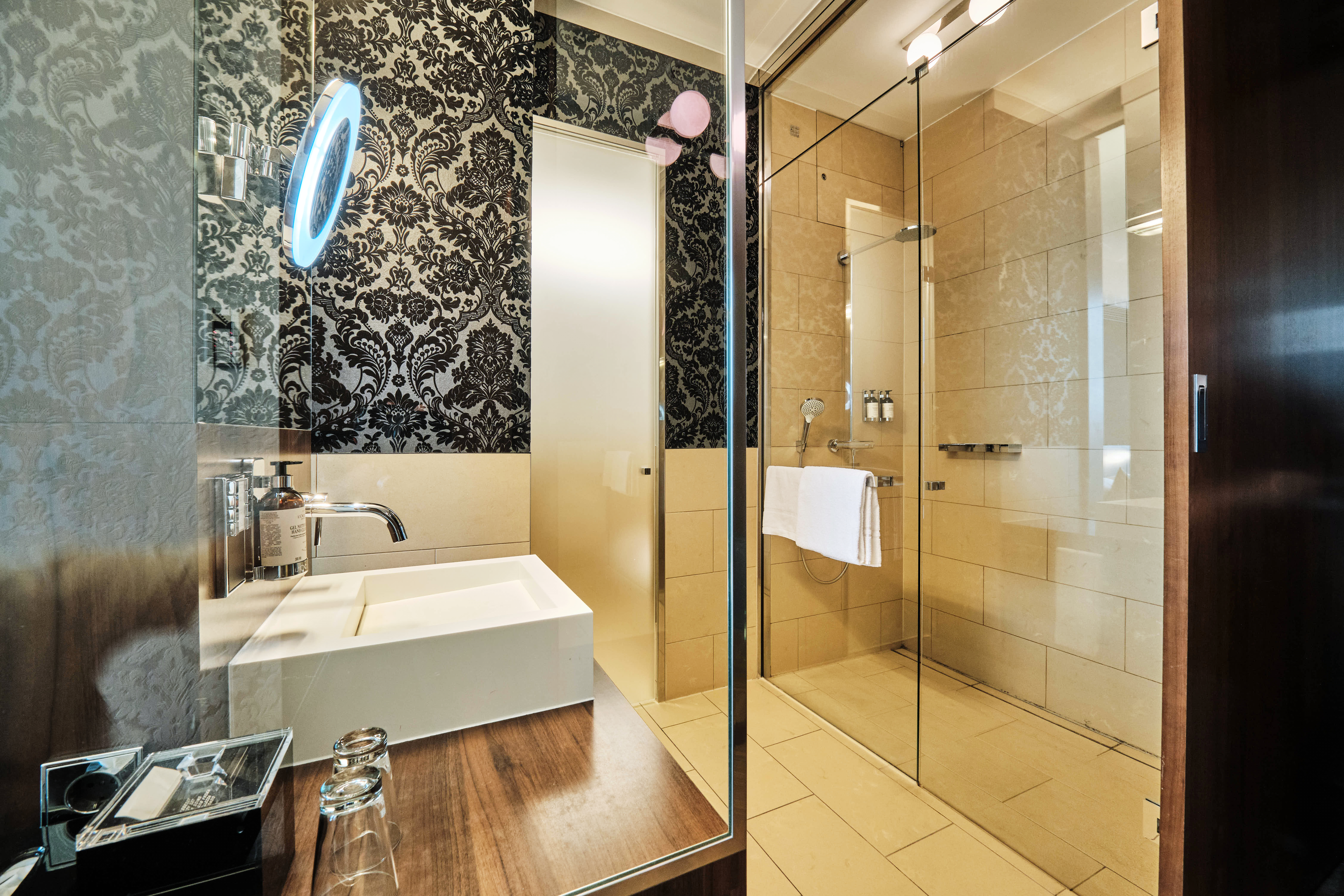 Badezimmer mit Dusche und Waschtisch im Premium Room.